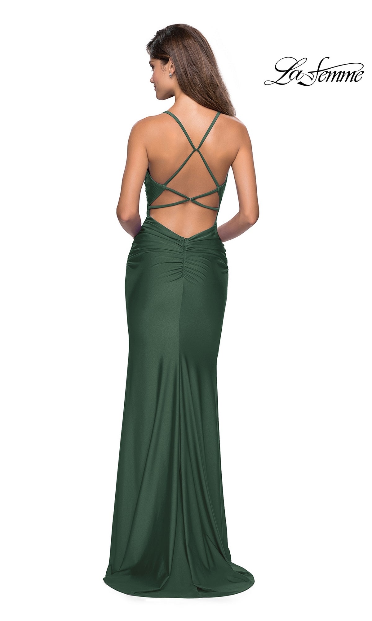 Woman wearing a floor-length, dark green La Femme Cowl-Neck Long Prom Dress 27501 with an open back and crisscross straps, standing sideways and facing away from the camera.